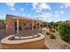 Relaxing outdoor living space with a covered patio, grill, seating, and desert landscape at 16444 W Chuparosa Ln, Surprise, AZ 85387