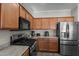 A well-lit kitchen with stainless steel appliances and wood cabinets against neutral walls at 16444 W Chuparosa Ln, Surprise, AZ 85387