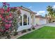 Charming white home with beautiful flower landscaping and green grass, with a beautiful red tile roof at 16662 S 37Th Way, Phoenix, AZ 85048