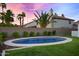 Private backyard oasis with an inviting pool, lush landscaping, and palm trees silhouetted against a vibrant sunset sky at 16662 S 37Th Way, Phoenix, AZ 85048