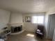 Cozy living room features a traditional fireplace, comfortable armchair, and bright window at 1831 W Mulberry Dr # 241, Phoenix, AZ 85015