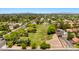Expansive aerial view showcasing a large grassy field, RV parking, surrounding homes and mountain views in the distance at 1910 E Citation Ln, Tempe, AZ 85284