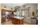 Well-lit kitchen with stainless steel appliances, a hanging pot rack and center island with granite countertops at 1910 E Citation Ln, Tempe, AZ 85284