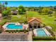 Aerial view of a community pool area with a clubhouse, swimming pools, and well-manicured lawns at 1910 E Citation Ln, Tempe, AZ 85284