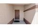 Covered entryway with a solid front door and neutral walls. The area is floored with concrete at 19523 N Carriage Ln, Surprise, AZ 85374
