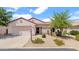 Charming single-story home showcasing desert landscaping, a tile roof, and an attached two-car garage at 19523 N Carriage Ln, Surprise, AZ 85374