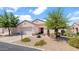 Inviting single-story home featuring desert landscaping, a tile roof, and an attached two-car garage at 19523 N Carriage Ln, Surprise, AZ 85374