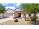 Charming single-story home with desert landscaping, a tile roof, and an attached two-car garage at 19523 N Carriage Ln, Surprise, AZ 85374