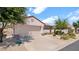 Side angle view of a single-story home with a two-car garage and desert landscaping at 19523 N Carriage Ln, Surprise, AZ 85374