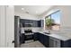 Well-lit kitchen features stainless steel appliances, navy blue cabinets and white marble countertops at 19523 N Carriage Ln, Surprise, AZ 85374