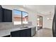 Bright kitchen featuring navy blue cabinets, a stainless steel sink, and views of the patio at 19523 N Carriage Ln, Surprise, AZ 85374