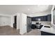 Stylish kitchen with navy blue cabinets, stainless steel appliances, and an open floor plan at 19523 N Carriage Ln, Surprise, AZ 85374