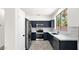 Modern kitchen features sleek, navy blue cabinets, stainless steel appliances and white marble backsplash at 19523 N Carriage Ln, Surprise, AZ 85374