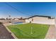 Backyard featuring a turquoise blue pool and artificial putting green at 2111 N Van Ness Ave, Tempe, AZ 85288