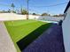Putting green and turquoise pool in a fenced backyard with desert landscaping at 2111 N Van Ness Ave, Tempe, AZ 85288