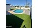 Backyard oval pool surrounded by concrete, synthetic grass, and desert landscaping at 2111 N Van Ness Ave, Tempe, AZ 85288