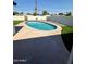 Backyard view of an oval pool featuring desert landscaping, a privacy wall, and clear blue skies at 2111 N Van Ness Ave, Tempe, AZ 85288