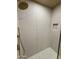 Beautiful shower with pebble floor, tiled walls, and gold fixtures at 2111 N Van Ness Ave, Tempe, AZ 85288