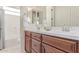 Bathroom featuring dual sinks with dark wood cabinets and an additional shower space at 23126 N 45Th Pl, Phoenix, AZ 85050