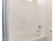 Bright white tub and shower featuring chrome fixtures and a built-in soap dish at 23126 N 45Th Pl, Phoenix, AZ 85050