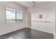 Bright bedroom featuring large window, gray walls, wood floors, and ballet bar for in-home fitness at 23126 N 45Th Pl, Phoenix, AZ 85050
