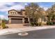 Charming two-story home with a three-car garage, beautiful brick driveway, and lush, flowering trees at 23126 N 45Th Pl, Phoenix, AZ 85050