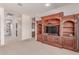 Cozy living room featuring a large entertainment center and seamless transition to the kitchen at 23126 N 45Th Pl, Phoenix, AZ 85050