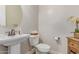 Charming powder room with a pedestal sink, round mirror, and decorative accents for a stylish touch at 23126 N 45Th Pl, Phoenix, AZ 85050