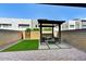 Inviting backyard featuring a modern pergola over a seating area, surrounded by artificial turf and stone pavers at 25326 N 19Th Dr, Phoenix, AZ 85085
