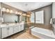 Luxurious bathroom with dual sinks, soaking tub, and a separate glass-enclosed shower for a spa-like experience at 25326 N 19Th Dr, Phoenix, AZ 85085