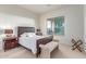Bedroom with a plush bed, a bench, and a side table at 27105 W Marco Polo Rd, Buckeye, AZ 85396