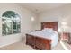 Bedroom featuring a dark wood bed frame, a side table, and a large window at 27105 W Marco Polo Rd, Buckeye, AZ 85396