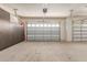 Garage with a built-in gray cabinet area and two access doors at 27105 W Marco Polo Rd, Buckeye, AZ 85396