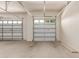Two car garage with bright white walls and two closed access doors at 27105 W Marco Polo Rd, Buckeye, AZ 85396