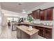 Bright and open kitchen with stone countertops, dark cabinetry and island with breakfast bar at 27105 W Marco Polo Rd, Buckeye, AZ 85396