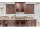 Modern kitchen design showcasing granite countertops, gas range, and ample dark wood cabinetry at 27105 W Marco Polo Rd, Buckeye, AZ 85396