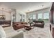 Open-concept living room with white tile floors, comfortable seating, and bright lighting at 27105 W Marco Polo Rd, Buckeye, AZ 85396