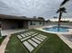 Well-maintained backyard with a covered patio, pool, and modern hardscape and landscape design at 3021 E Shangri La Rd, Phoenix, AZ 85028