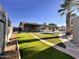Landscaped backyard featuring an inground pool, artificial grass, and a mature palm tree at 3021 E Shangri La Rd, Phoenix, AZ 85028
