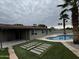 Well-maintained backyard with a covered patio, pool, and modern hardscape and landscape design at 3021 E Shangri La Rd, Phoenix, AZ 85028