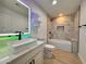 Updated bathroom featuring modern fixtures, a soaking tub, and a stylish vanity with colorful LED mirror at 3021 E Shangri La Rd, Phoenix, AZ 85028
