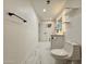 Bright bathroom featuring marble floors, white fixtures, illuminated mirror, and floating shelves at 3021 E Shangri La Rd, Phoenix, AZ 85028