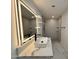 Modern bathroom with a sleek vanity, LED mirror, and walk-in shower featuring geometric tile at 3021 E Shangri La Rd, Phoenix, AZ 85028