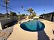 Backyard view featuring a pool with stone border, tropical landscaping, and clear blue skies at 3021 E Shangri La Rd, Phoenix, AZ 85028