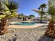 Lush backyard view with tropical palms framing the pool and the home's exterior at 3021 E Shangri La Rd, Phoenix, AZ 85028