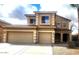 Two-story tan home featuring a spacious three-car garage and well-maintained landscaping at 3057 E Pinto Valley Rd, San Tan Valley, AZ 85143