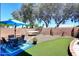 Backyard with seating area, artificial grass, and hammock strung up next to brick privacy wall at 3122 E Kristal Way, Phoenix, AZ 85050