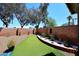 View of the backyard with a lush artificial lawn and accent landscaping at 3122 E Kristal Way, Phoenix, AZ 85050