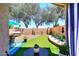 Landscaped backyard with artificial turf, decorative rock, and a privacy wall with a fountain at 3122 E Kristal Way, Phoenix, AZ 85050