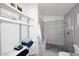 Bathroom featuring open shelving with towels next to large tiled shower with a built in bench at 3122 E Kristal Way, Phoenix, AZ 85050